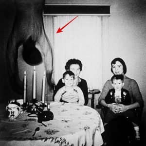 An unexpected guest - 1950s: Two boys sit happily on their mother's laps but a pretty terrifying and unexpected guest has also dropped in.